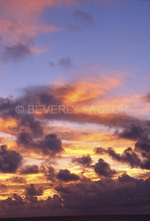 Islands;sunsets;sky;clouds;colorful;blue water;sun;yellow;red;pink;sillouettes;blue;silver banks domincon republic